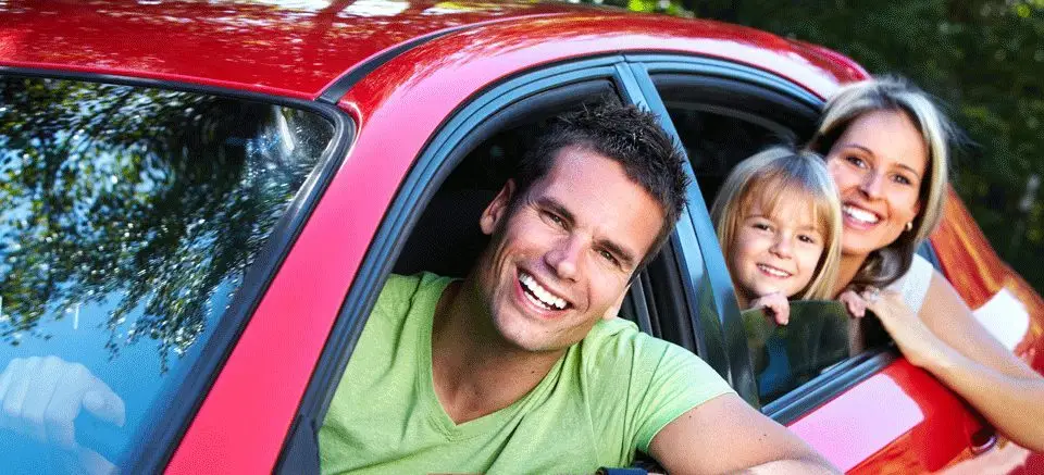 a man, a woman and a child in a car